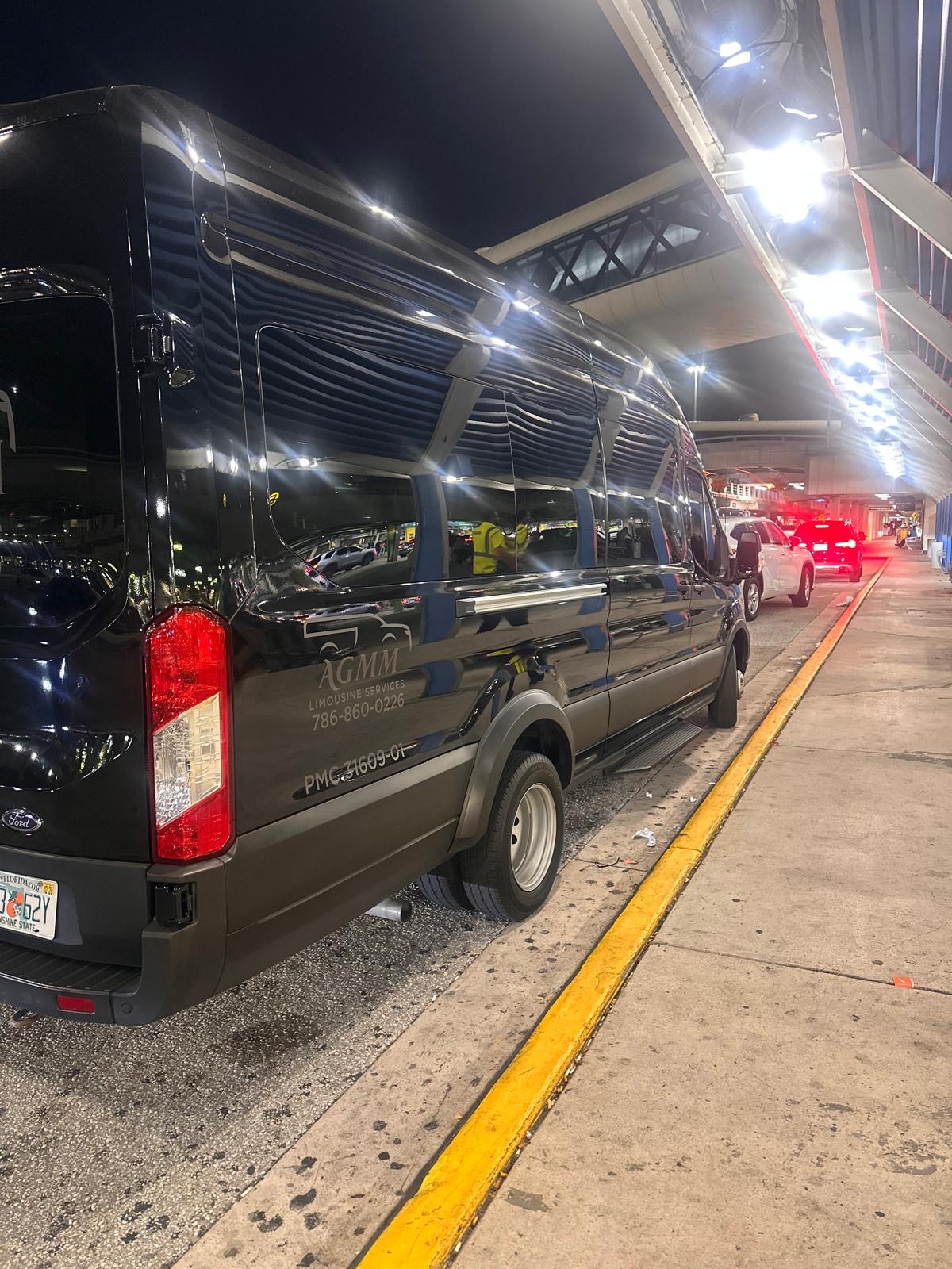 Black Ford Transit at an airport pickup area